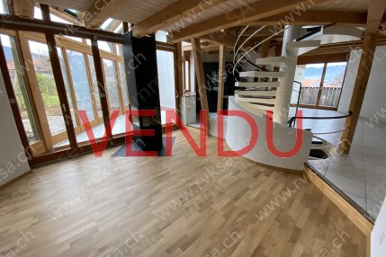 Séjour avec vue sur la cuisine, la véranda et l'escalier desservant tous les étages